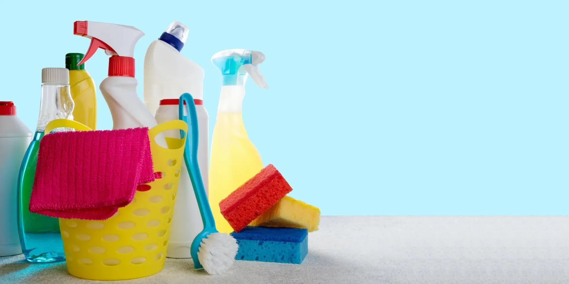 Basket with cleaning products on blue background. Cleaning with supplies, cleaning service